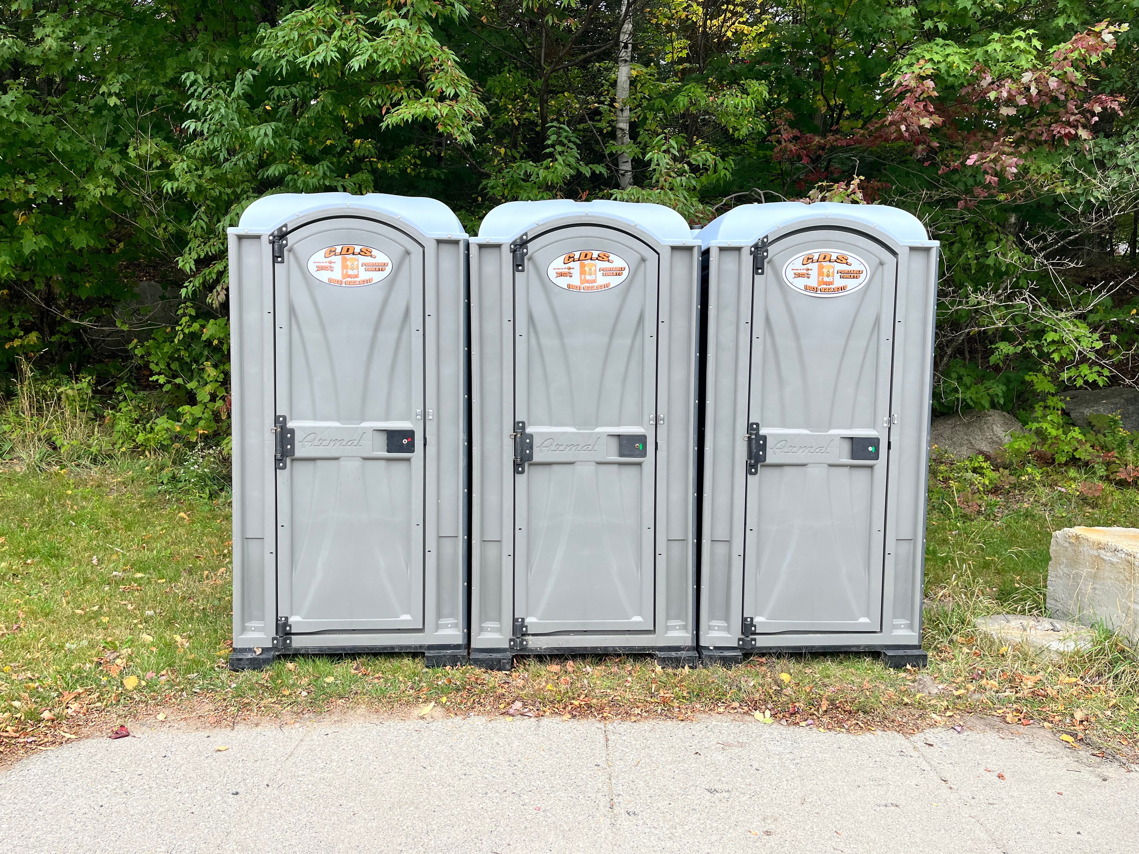 Postcard front — portable restroom units lined up for a large event